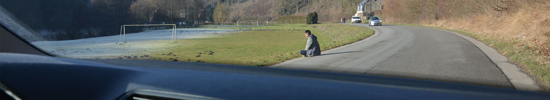 Homme assis au bord de la route
